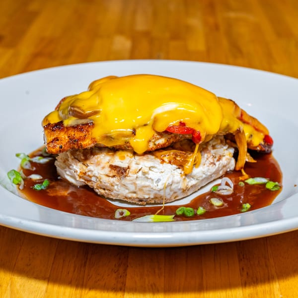 Lost Lion's chicken and biscuit dish, topped with melted cheese, peppers, and gravy.